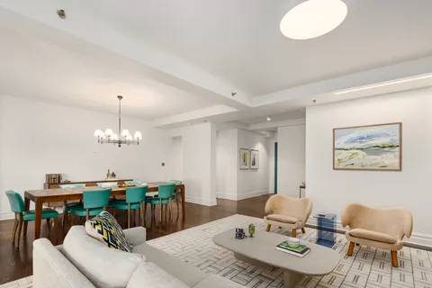 a living room with furniture a chandelier and a dining table