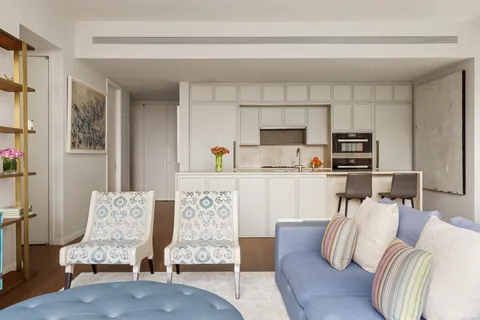 a living room with furniture and a kitchen view