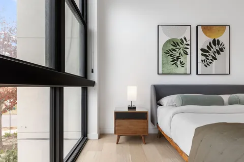 a bedroom with a bed and a painting on the wall