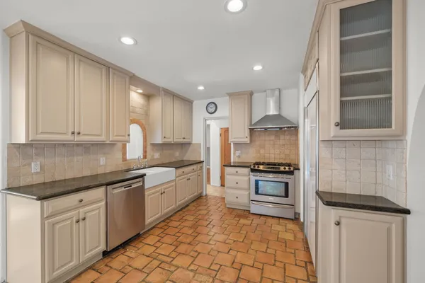 a kitchen with granite countertop a sink stainless steel appliances and cabinets