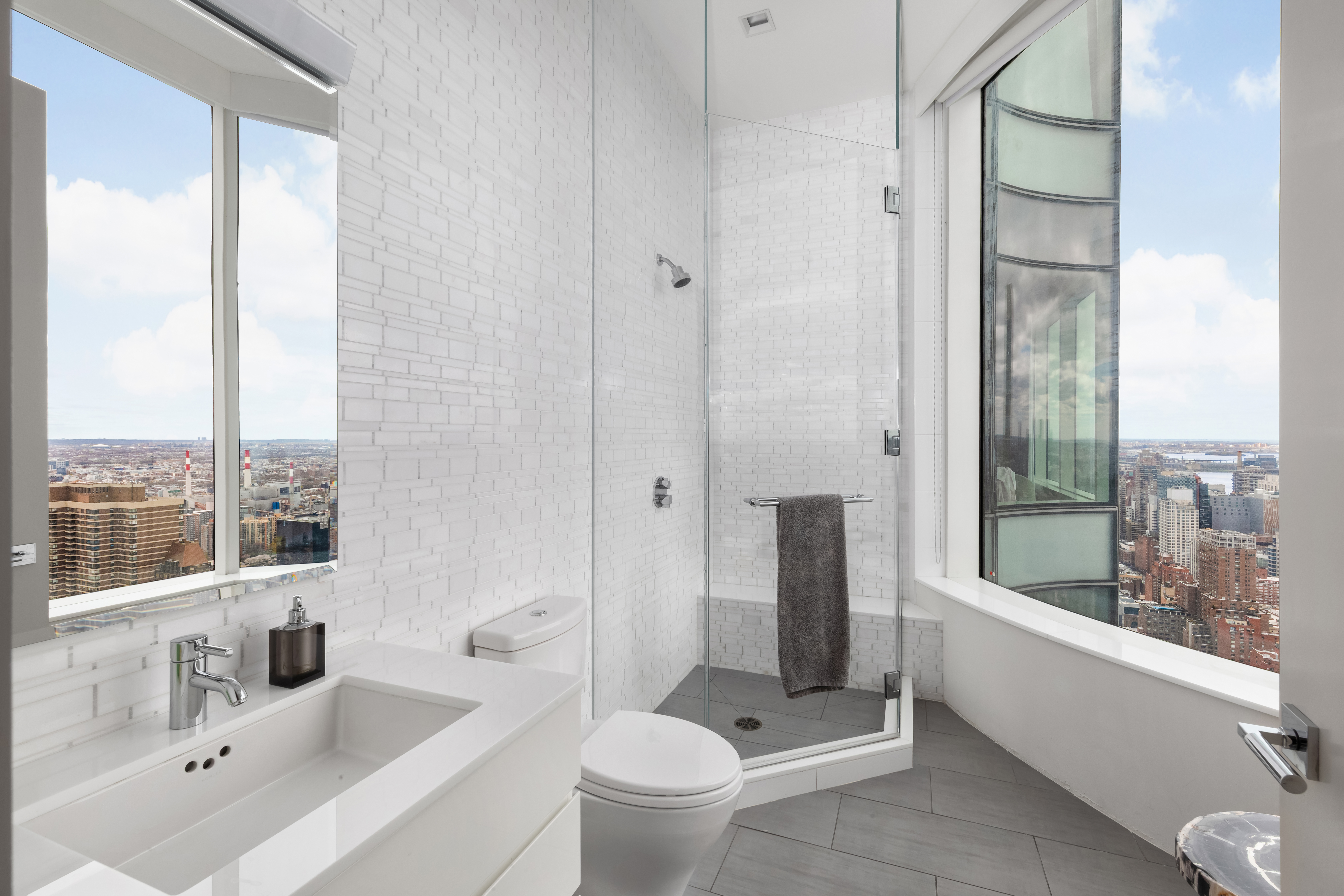 252 East 57th Street, Unit 60A Manhattan, NY 10022 - Photo 19 of 28 a bathroom with a bathtub shower sink mirror and toilet