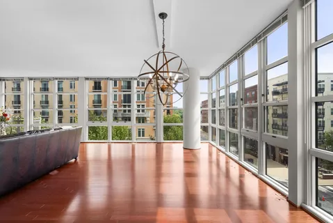 a view of a big room with wooden floor and windows