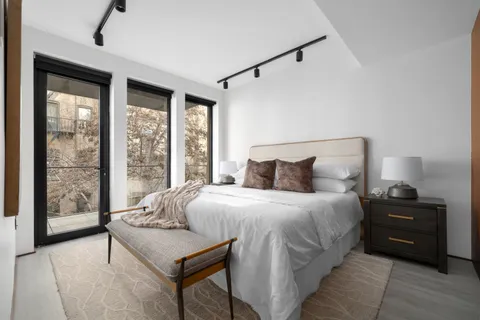 a bedroom with a bed and a large window