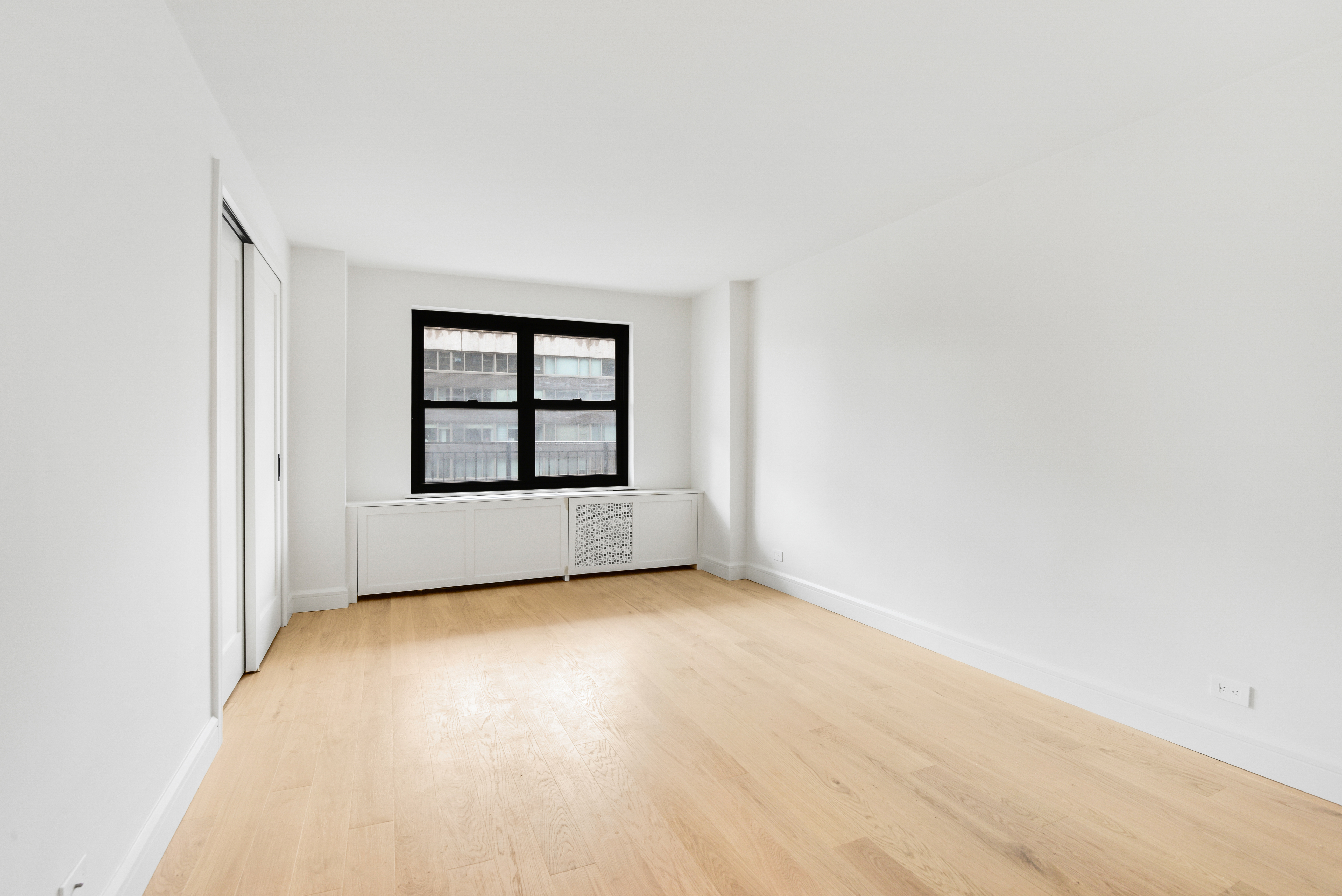205 West End Avenue, Unit 15H Manhattan, NY 10023 - Photo 10 of 17 an empty room with windows and mirror