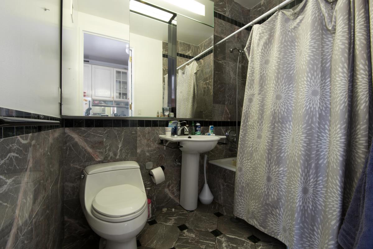 250 East 54th Street, Unit 22B Manhattan, NY 10022 - Photo 5 of 11 a bathroom with a sink toilet and a mirror