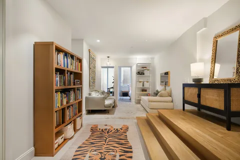 a living room with furniture and a book shelf