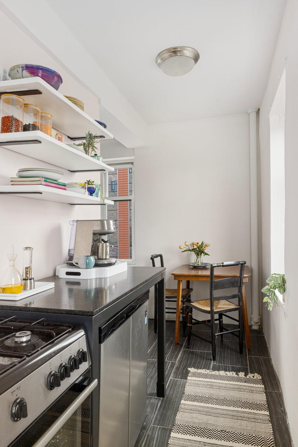 233 West 99th Street, Unit 19A Manhattan, NY 10025 - Photo 7 of 10 a kitchen with a stove and cabinets
