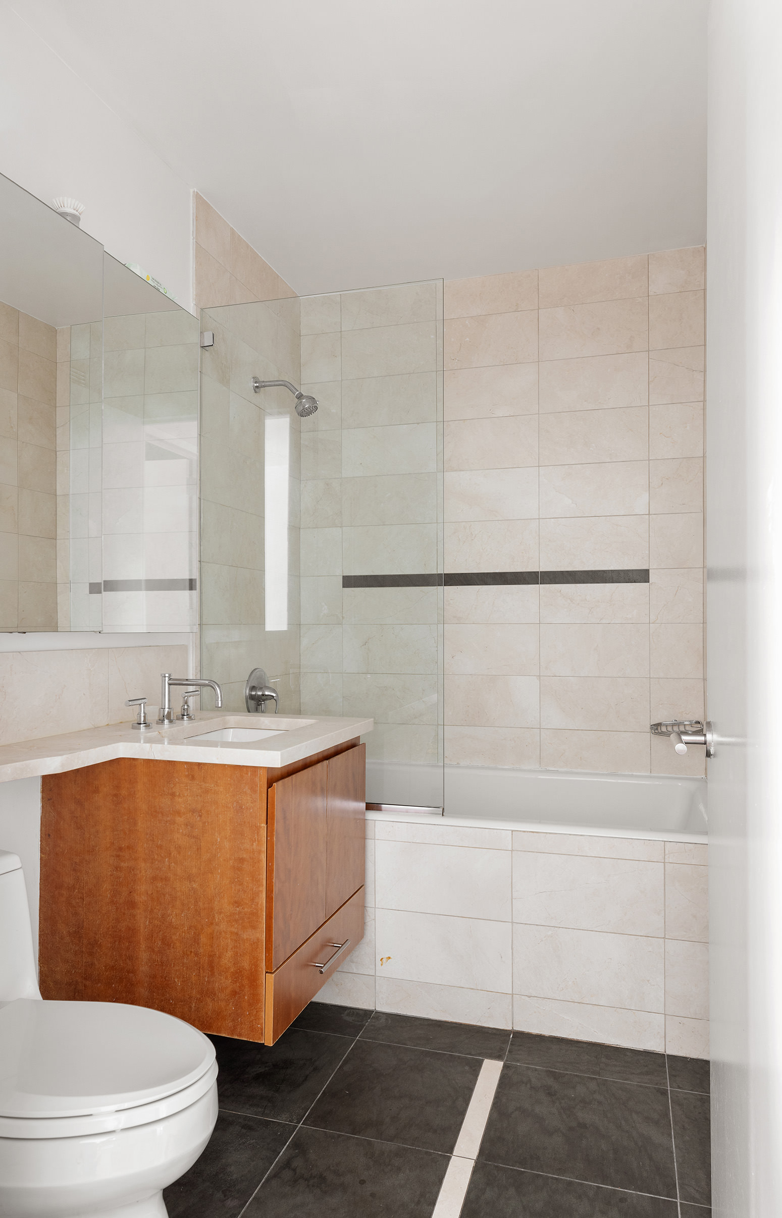 255 Hudson Street, Unit 6F Manhattan, NY 10013 - Photo 6 of 7 a bathroom with a sink a toilet and shower