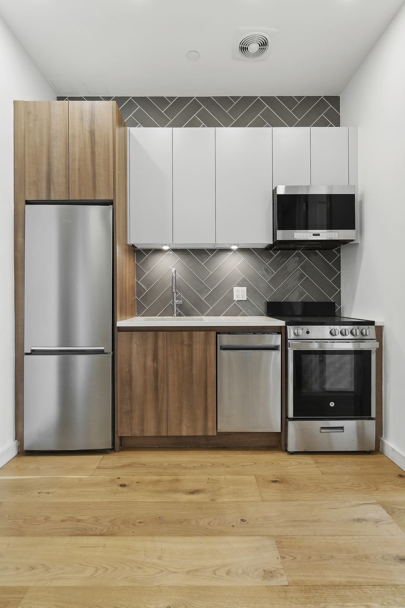 138 Schaefer Street, Unit 3A Brooklyn, NY 11207 - Photo 3 of 10 a kitchen with granite countertop a refrigerator and a stove