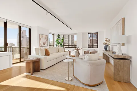 a living room with furniture a large window and wooden floor