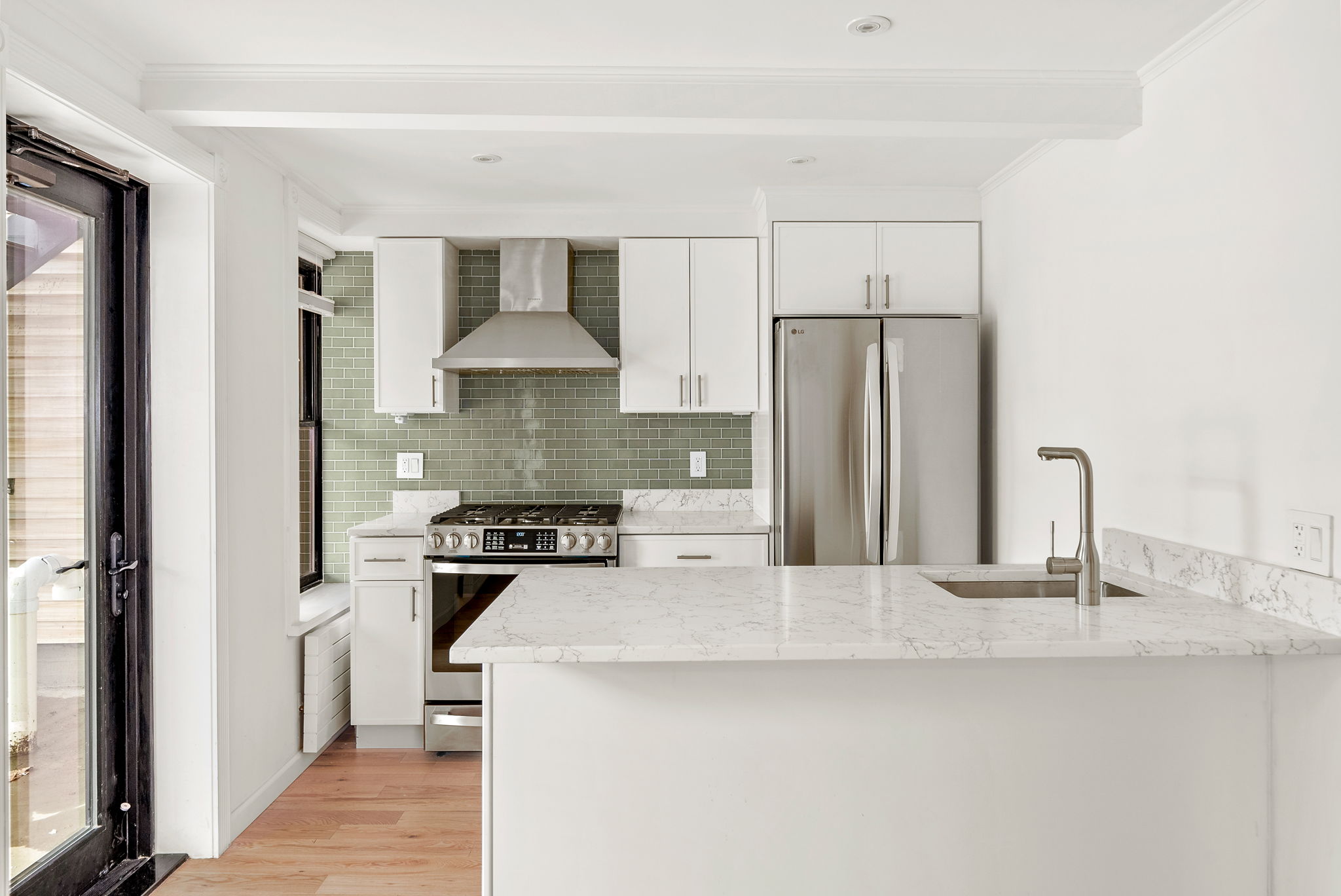 54 East 4th Street, Unit 1 Brooklyn, NY 11218 - Photo 3 of 12 a kitchen with stainless steel appliances granite countertop a sink stove and refrigerator