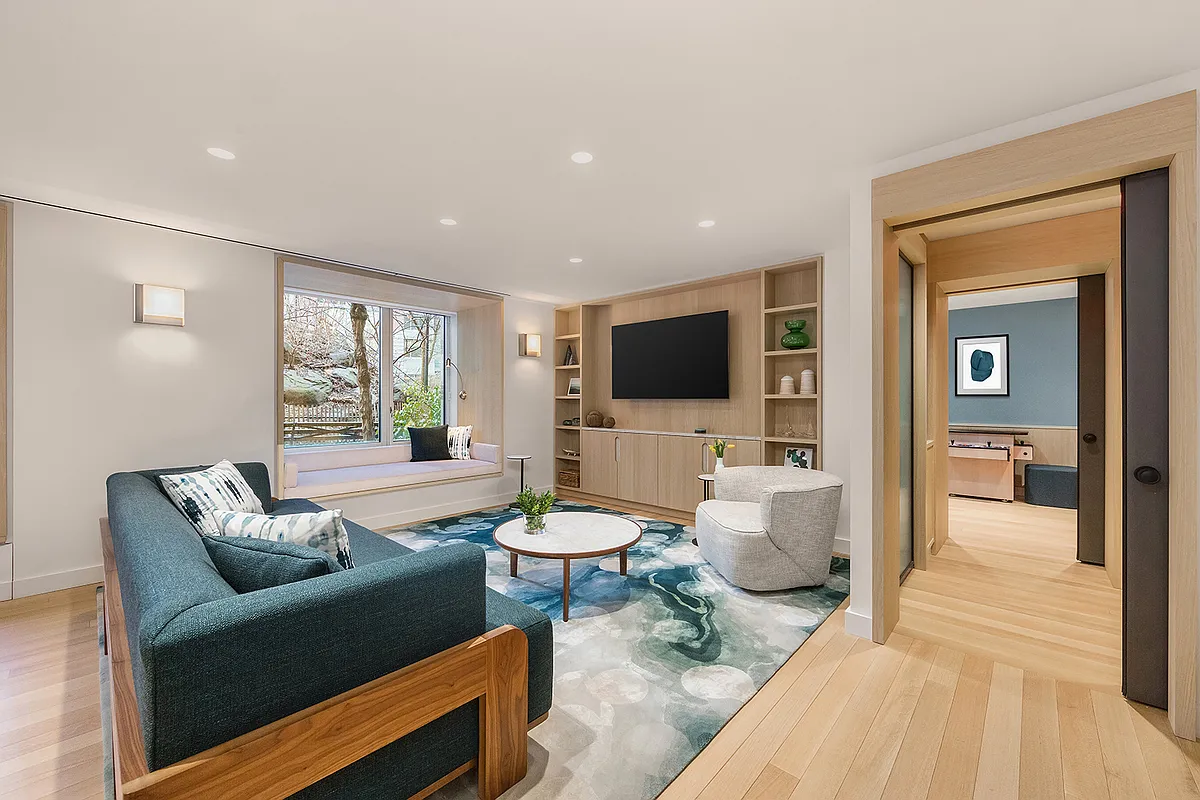 20 River Terrace, Unit 14C Manhattan, NY 10282 - Photo 8 of 18 a living room with furniture and a flat screen tv