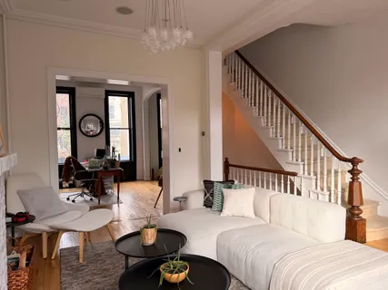 a living room with furniture chandelier and a wooden floor