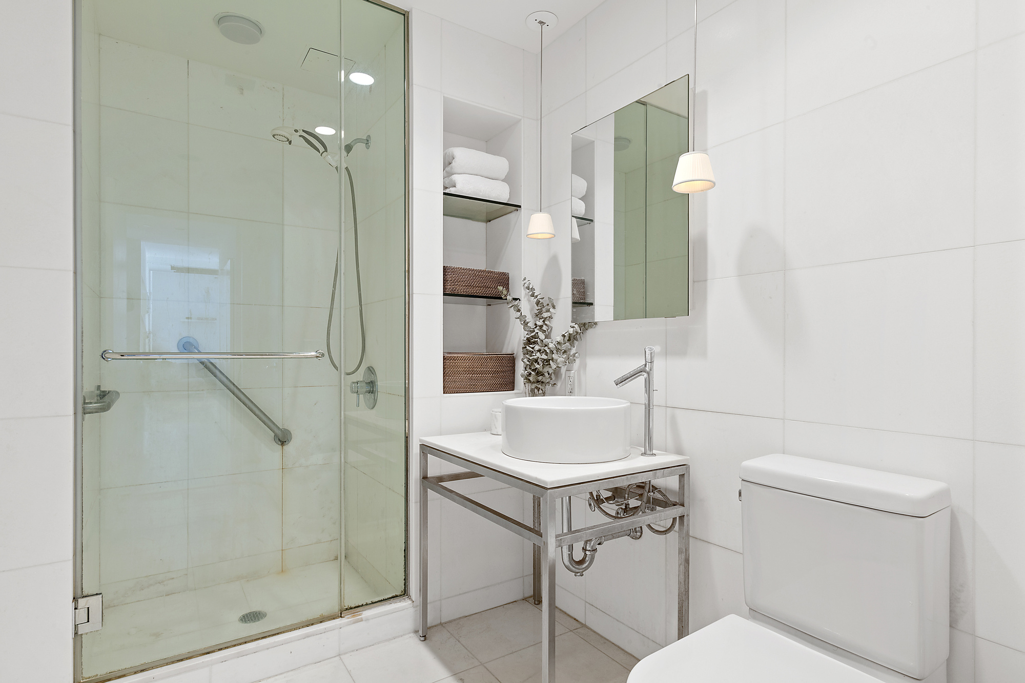 15 Broad Street, Unit 1601 Manhattan, NY 10005 - Photo 5 of 16 a bathroom with a sink toilet vanity and shower