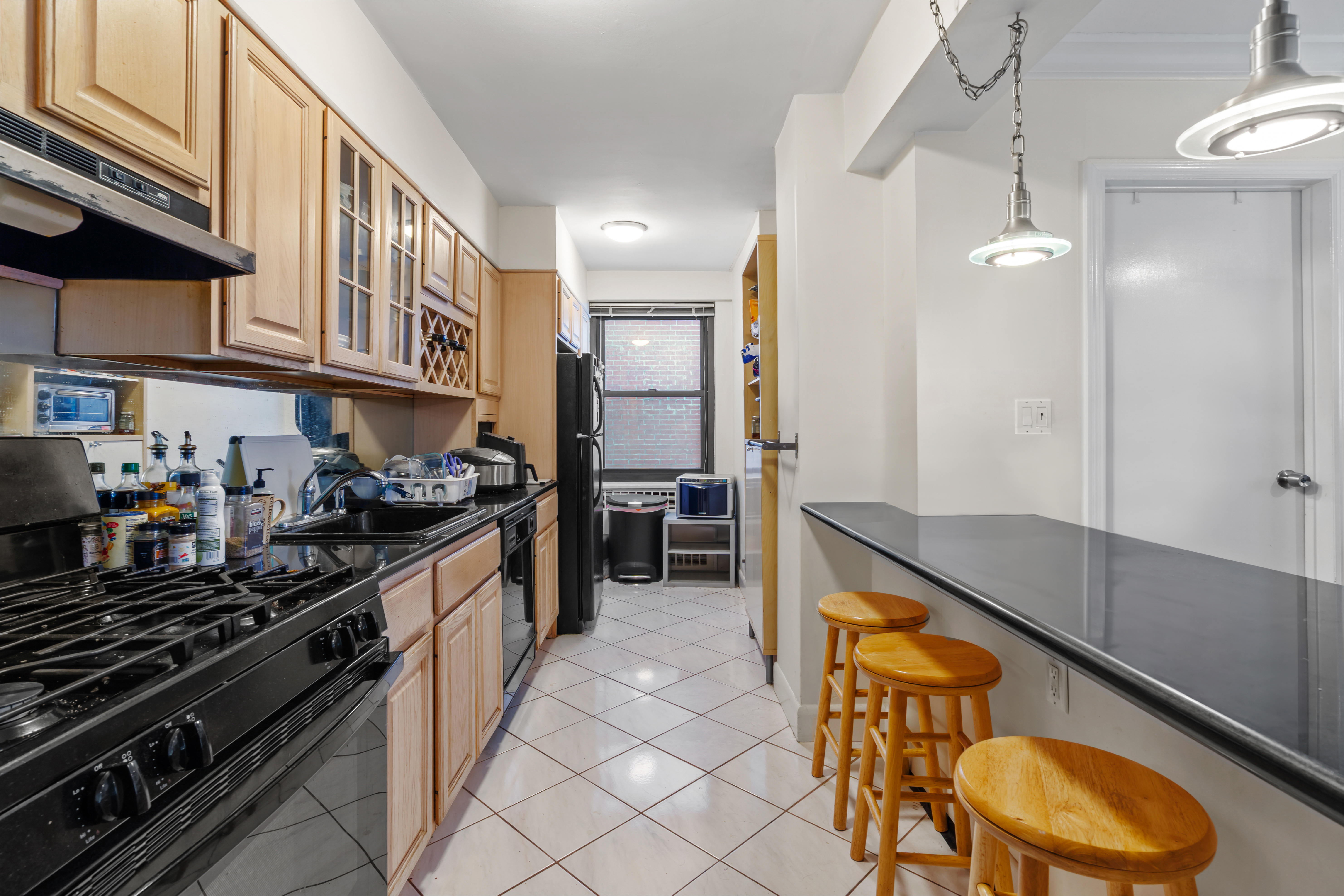 135 East 54th Street, Unit 3H Manhattan, NY 10022 - Photo 2 of 7 a kitchen with stainless steel appliances granite countertop a stove and a refrigerator