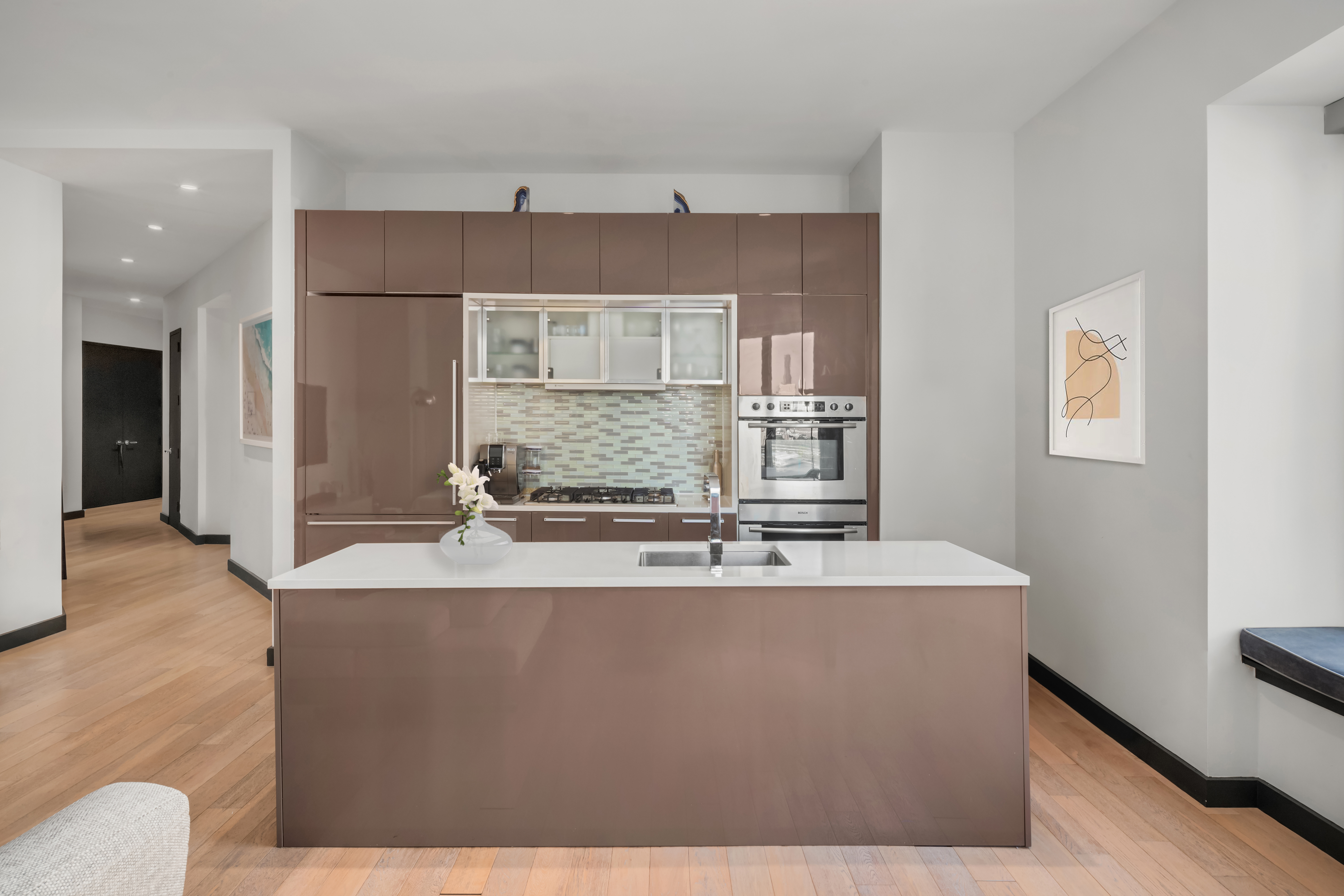 75 Wall Street, Unit 22O Manhattan, NY 10005 - Photo 4 of 11 a large kitchen with kitchen island a sink stainless steel appliances and cabinets
