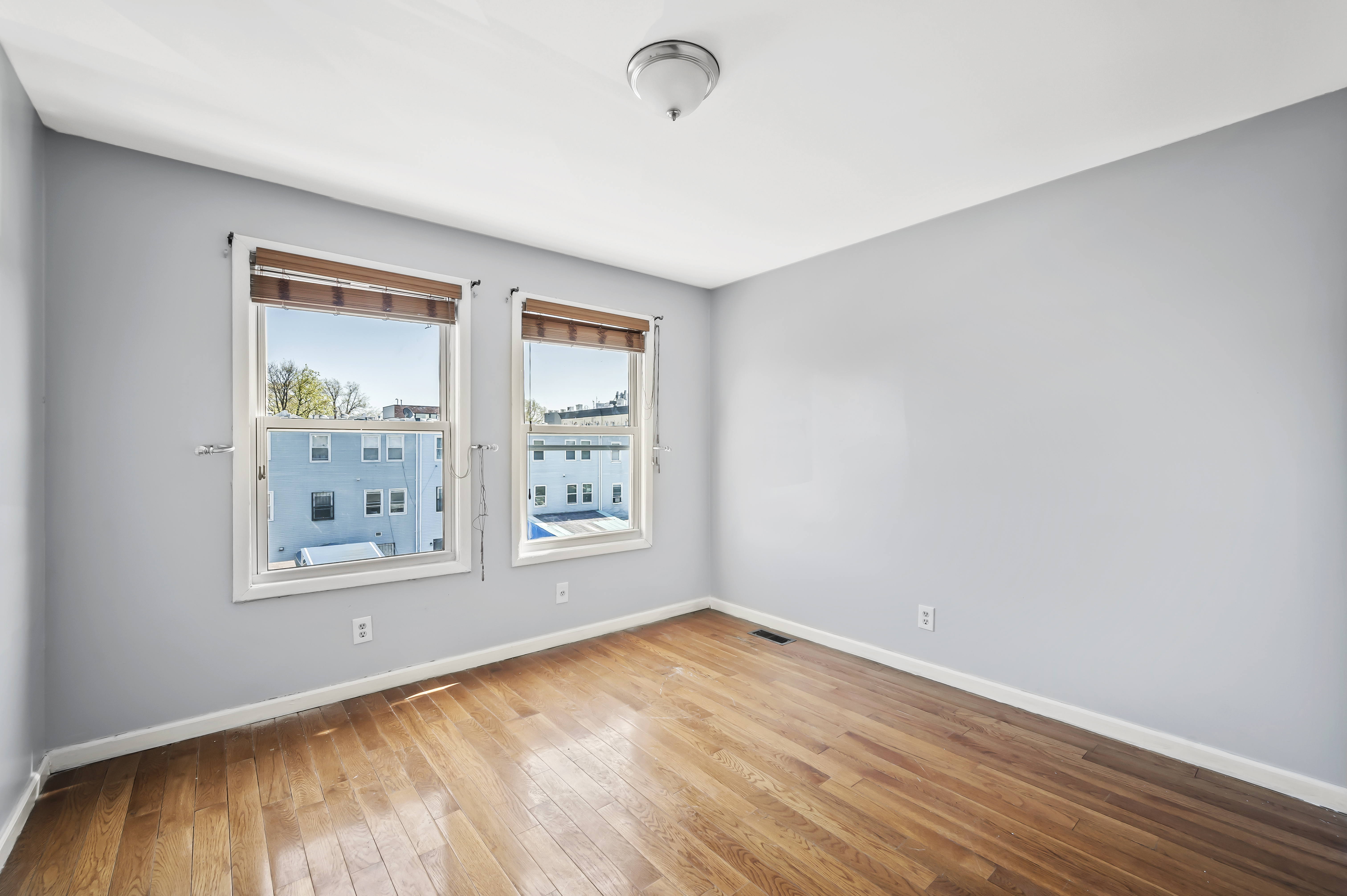 930 Jefferson Avenue, Unit 2 Brooklyn, NY 11221 - Photo 7 of 12 an empty room with wooden floor and windows