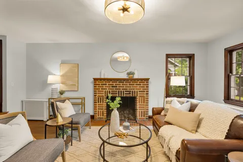 a living room with furniture chandelier and a fireplace