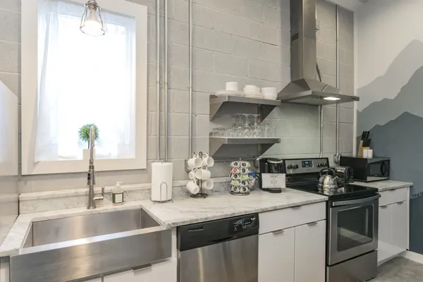 a kitchen with granite countertop a sink stainless steel appliances and cabinets
