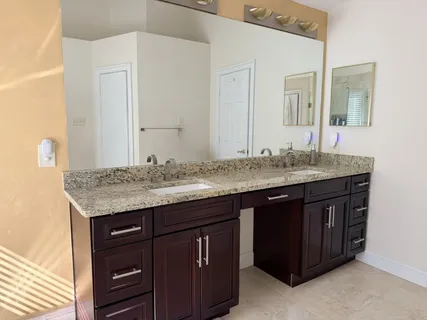 a bathroom with a granite countertop sink and a mirror