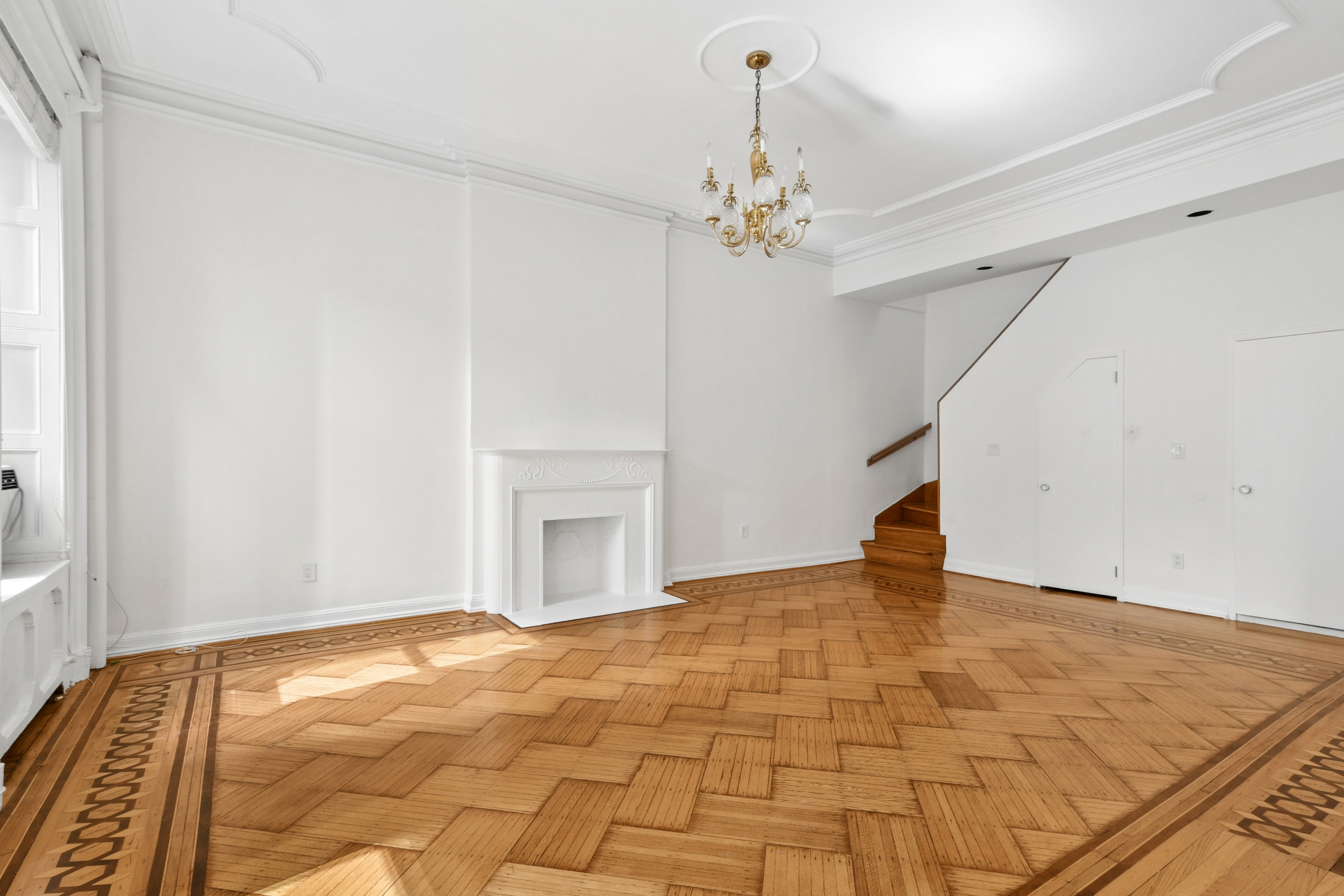 109 East 38th Street, Unit 3A Manhattan, NY 10016 - Photo 2 of 13 a view of an empty room with chandelier fan and wooden floor