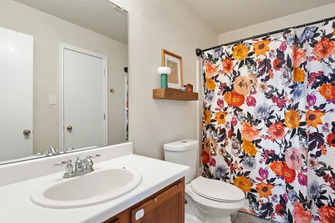 a bathroom with a sink and a mirror with toilet