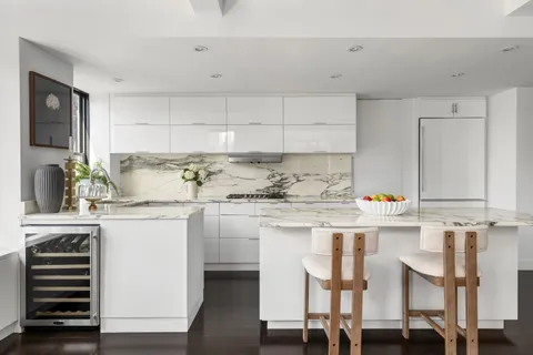 a kitchen with granite countertop white cabinets and white appliances