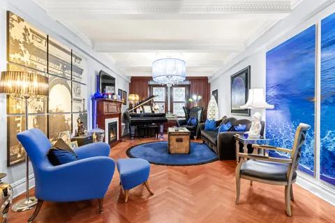 a living room with furniture a fireplace and a chandelier