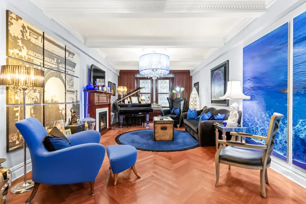a living room with furniture a fireplace and a chandelier
