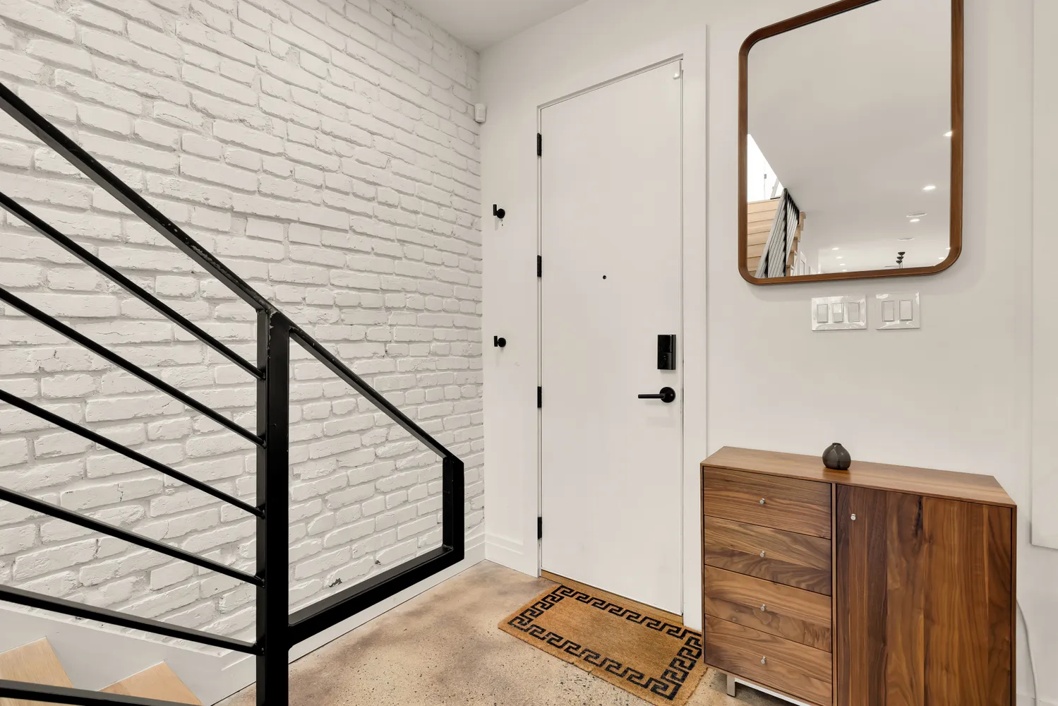 a view of a hallway with wooden floor and stairs