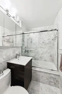 a bathroom with a sink toilet a mirror and shower