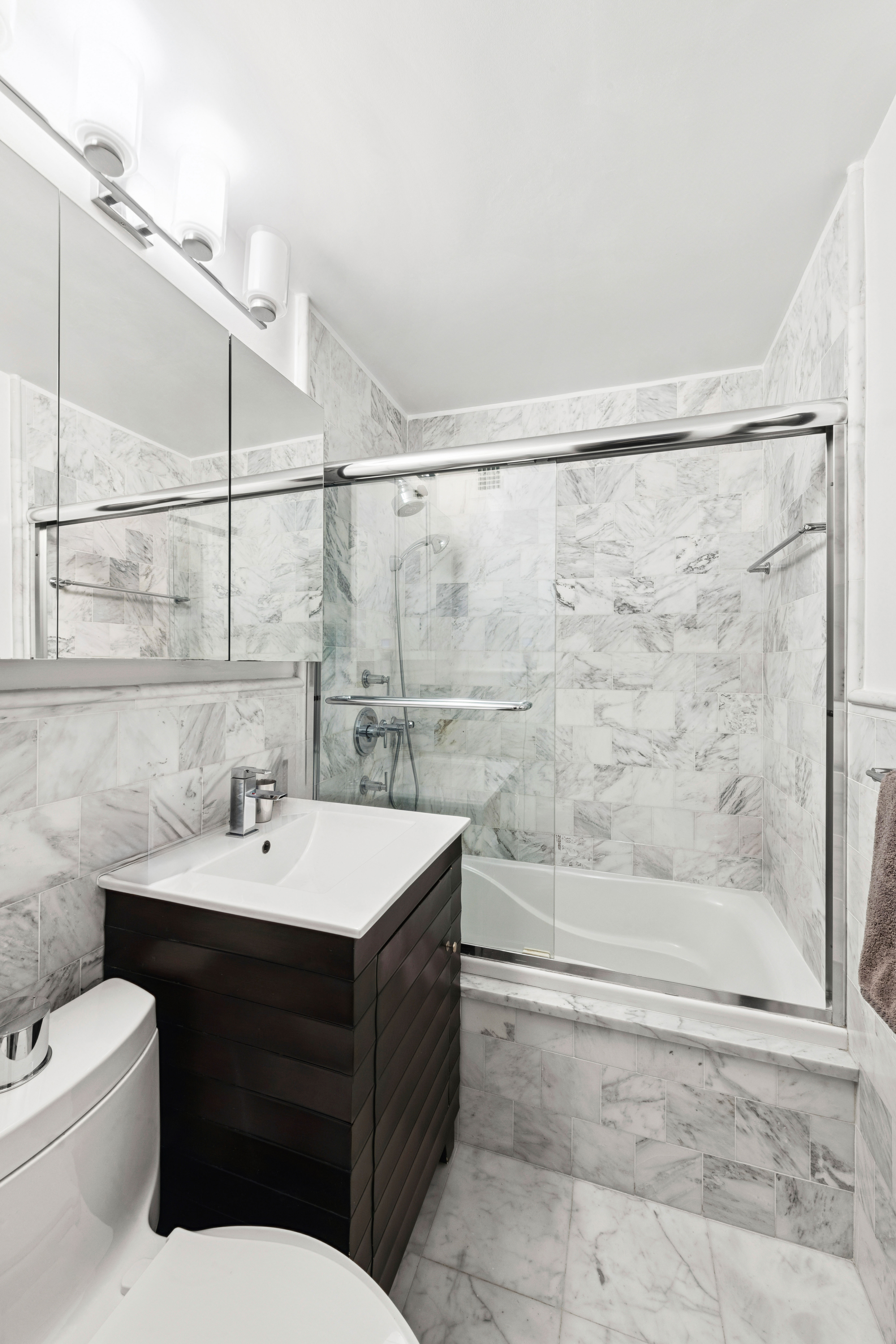 180 West End Avenue, Unit 14G Manhattan, NY 10023 - Photo 6 of 9 a bathroom with a sink toilet a mirror and shower