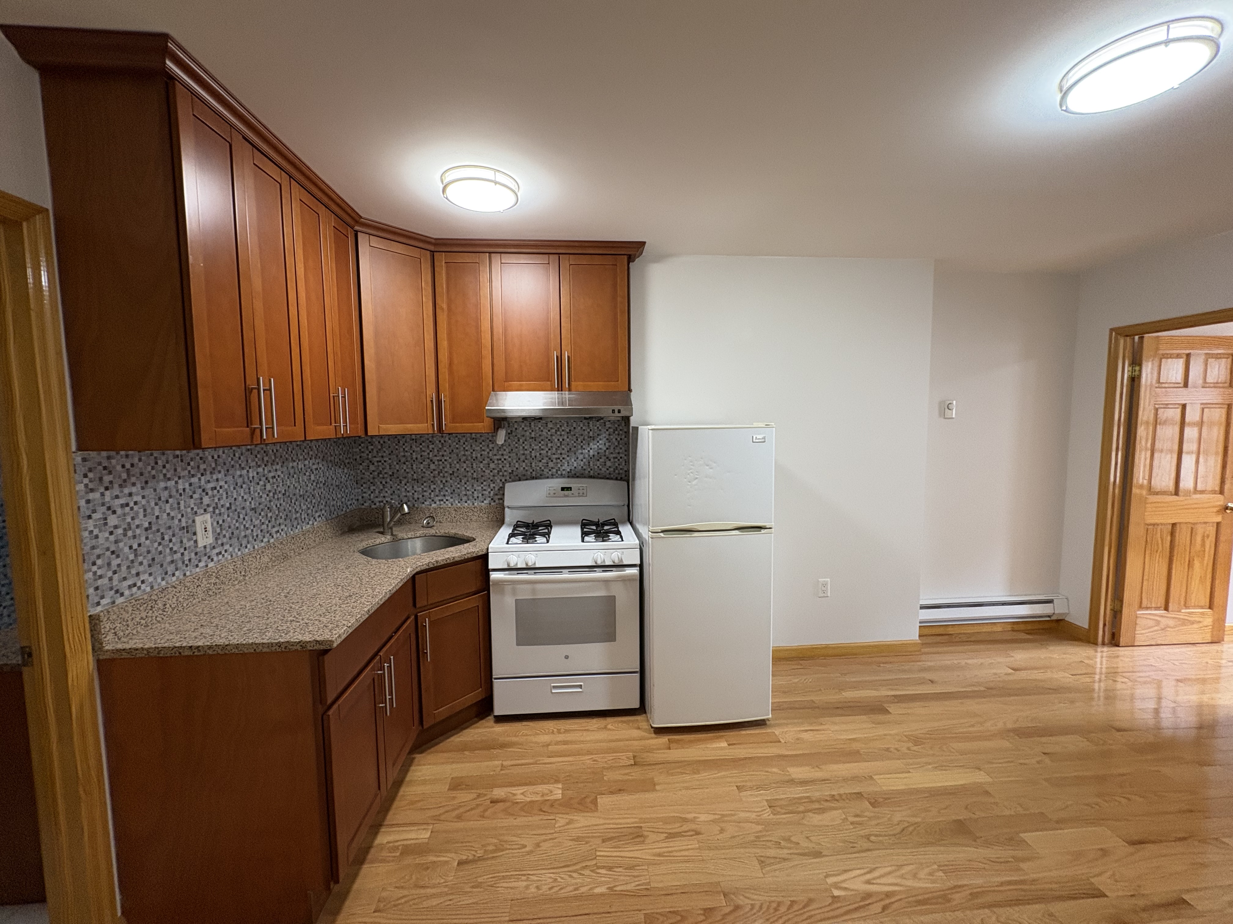 38 Ludlow Street, Unit 15 Manhattan, NY 10002 - Photo 10 of 16 a kitchen with a stove cabinets and wooden floor