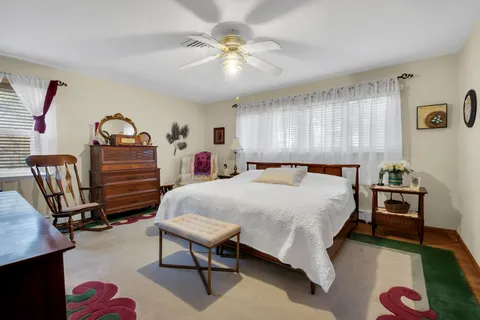 a bedroom with a bed a chandelier and a dresser