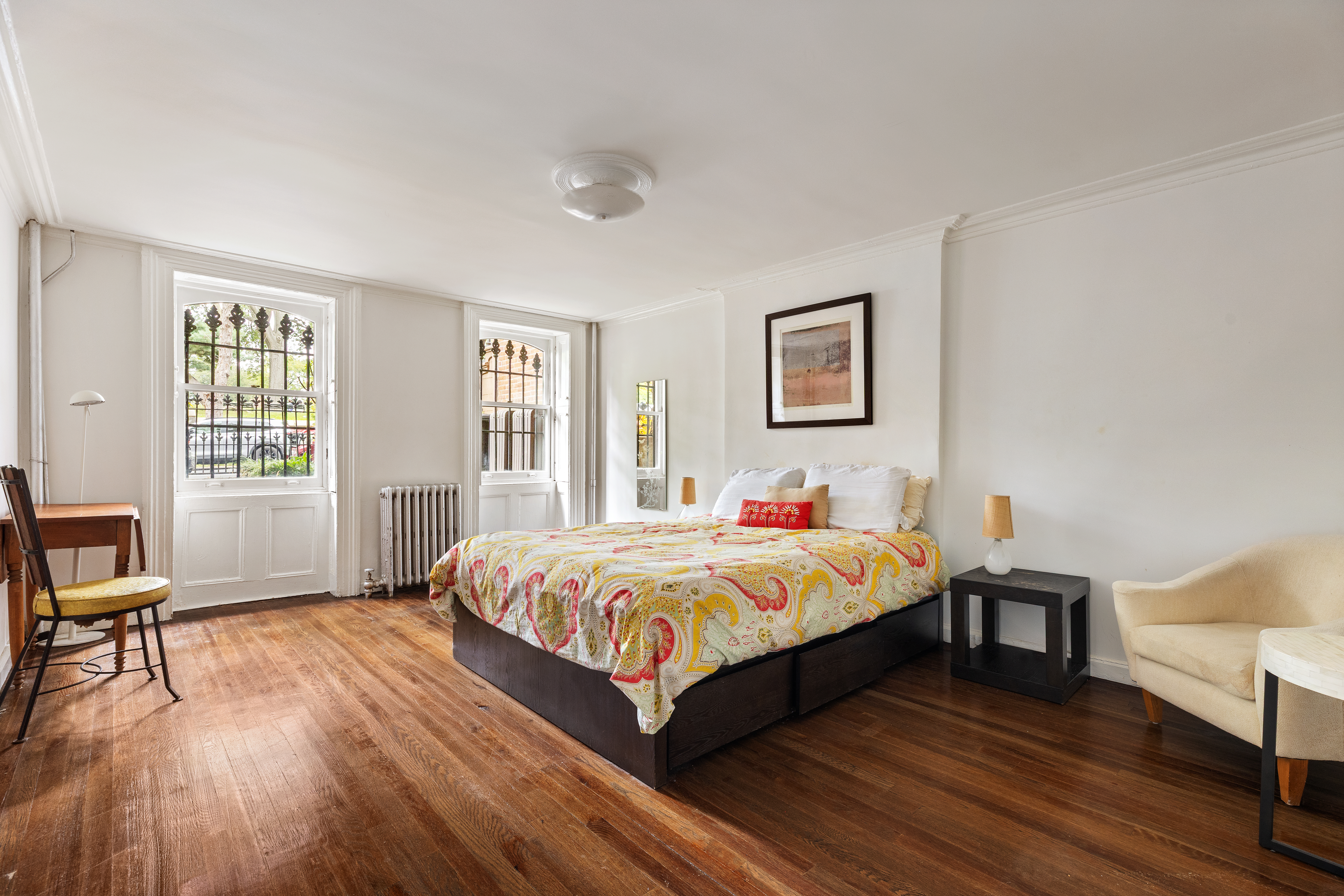 152 Dekalb Avenue Brooklyn, NY 11217 - Photo 22 of 27 a bedroom with a bed and a table in it with wooden floor