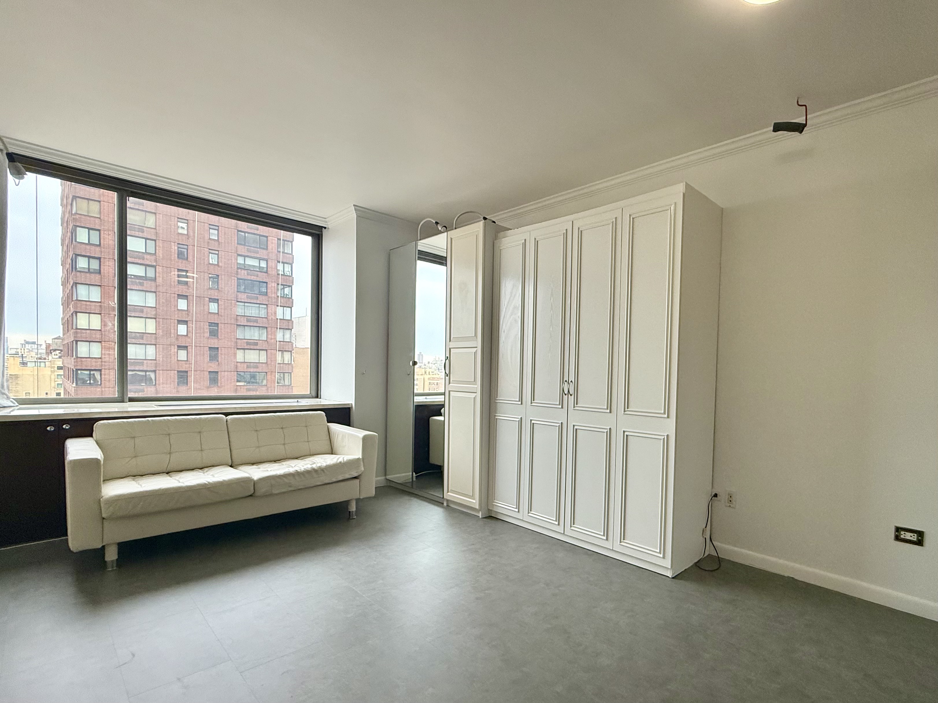111 West 67th Street, Unit 22K Manhattan, NY 10023 - Photo 1 of 14 a living room with furniture and a large window