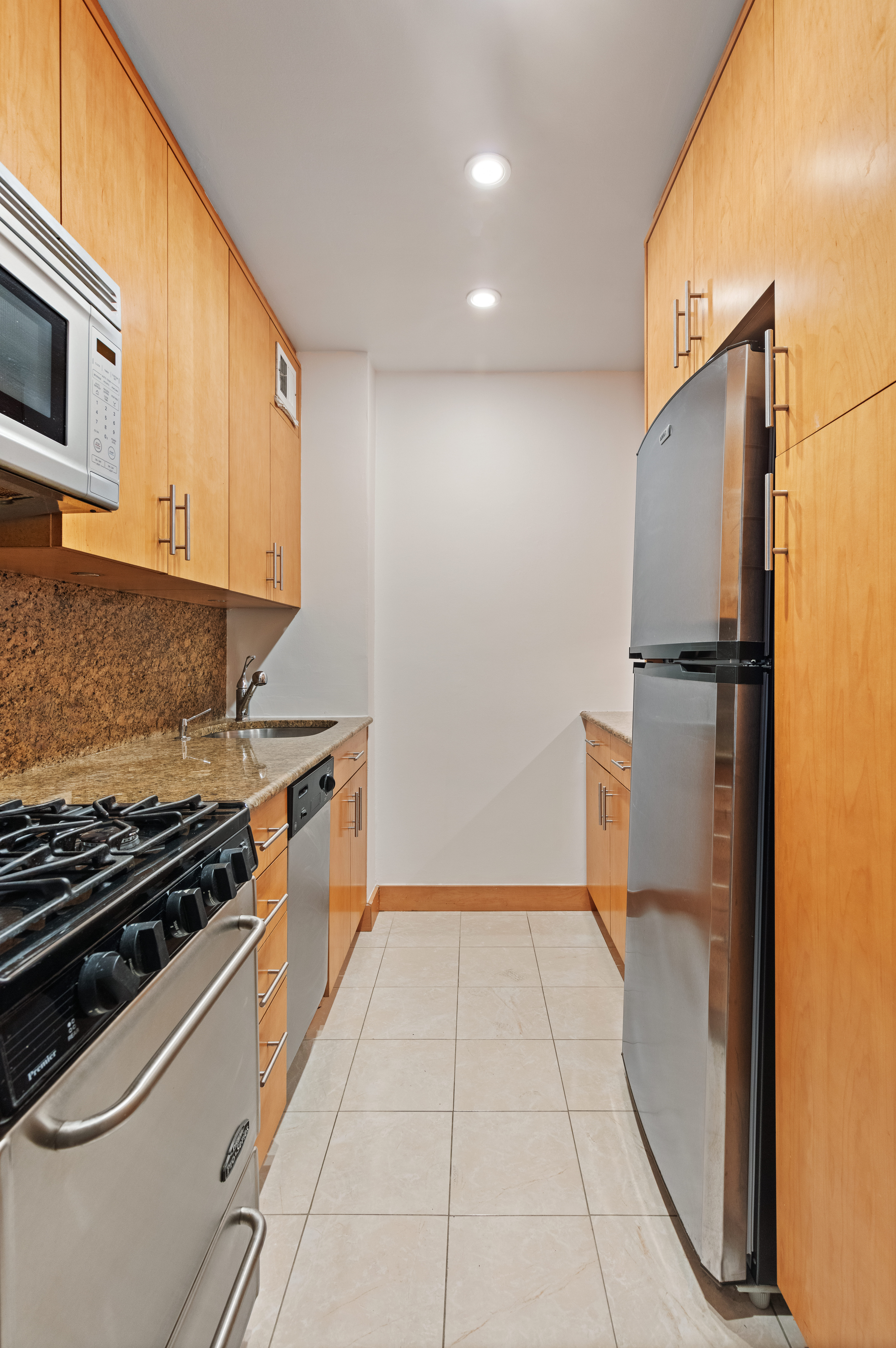 30 East 9th Street, Unit 2II Manhattan, NY 10003 - Photo 6 of 10 a kitchen with a refrigerator stove and microwave