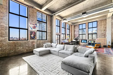 a living room with furniture and a floor to ceiling window