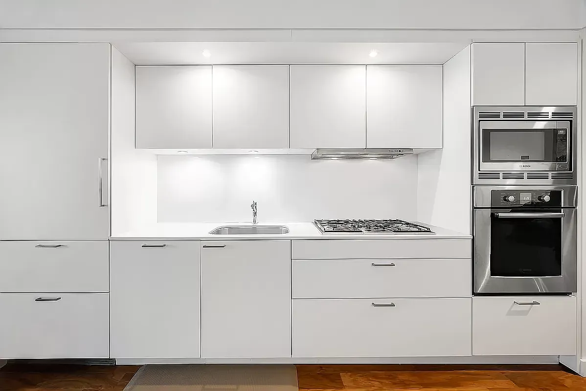 84 White Street, Unit 3A Manhattan, NY 10013 - Photo 2 of 6 a kitchen with granite countertop white cabinets and stainless steel appliances