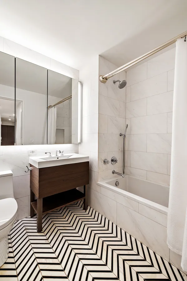 a bathroom with a sink a toilet a mirror and shower