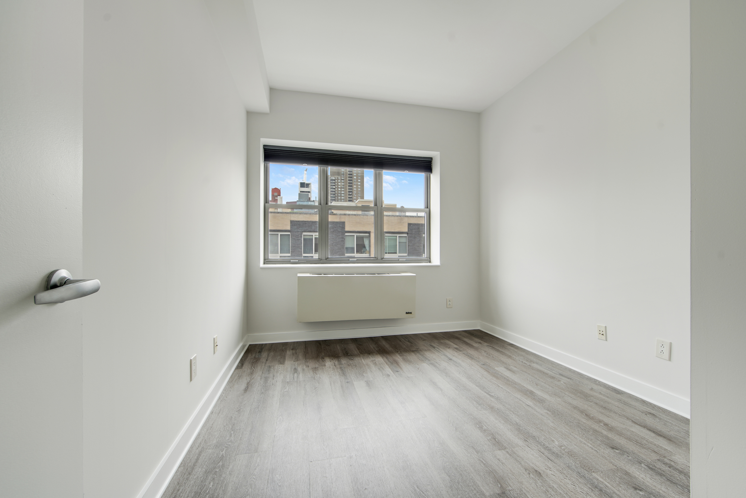 516 West 47th Street, Unit N7A Manhattan, NY 10036 - Photo 10 of 19 an empty room with wooden floor and windows