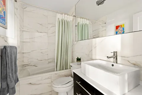 a bathroom with a sink a toilet and shower curtain