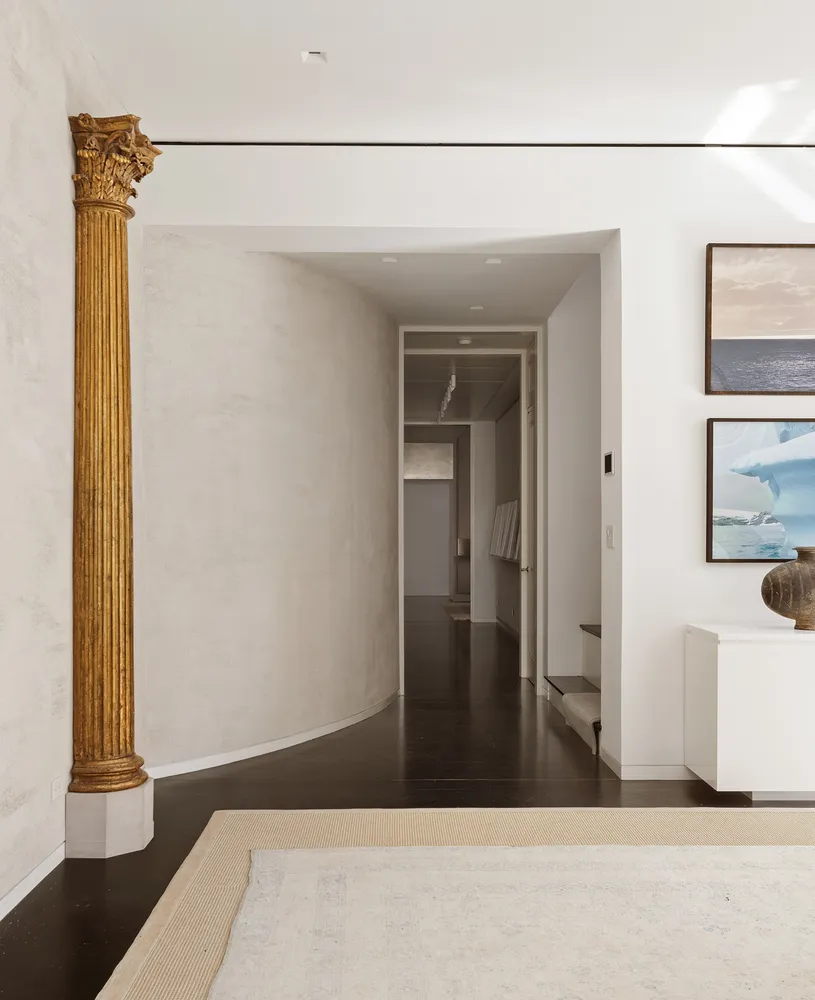 a view of a hallway with a door and wooden floor