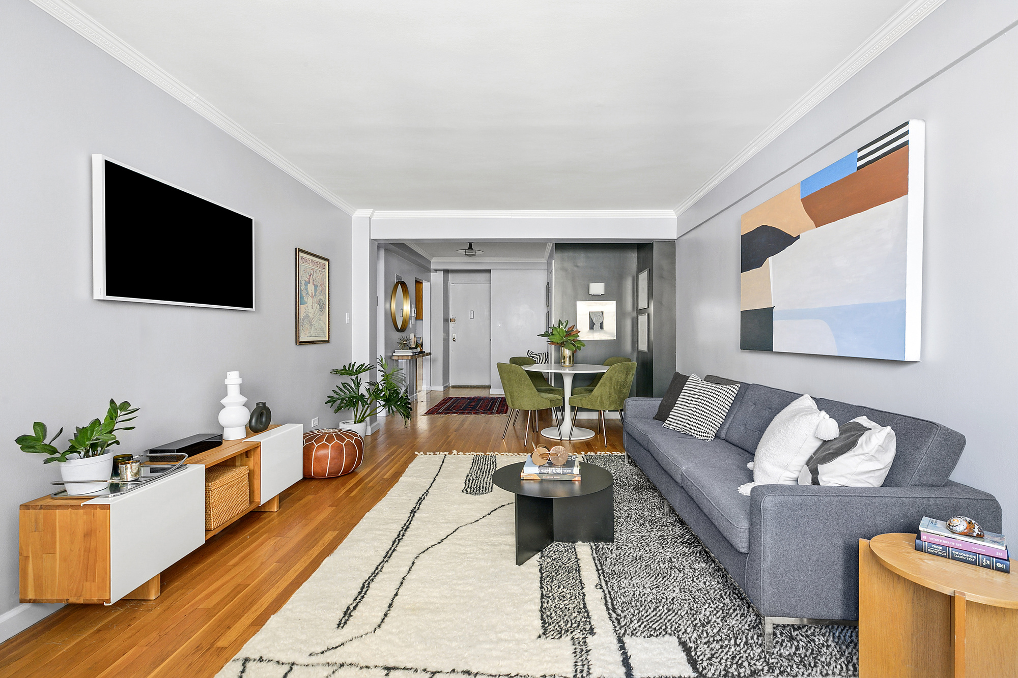 201 East 15th Street, Unit 7AJ Manhattan, NY 10003 - Photo 3 of 10 a living room with furniture and a flat screen tv