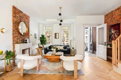 a living room with fireplace furniture and a large window