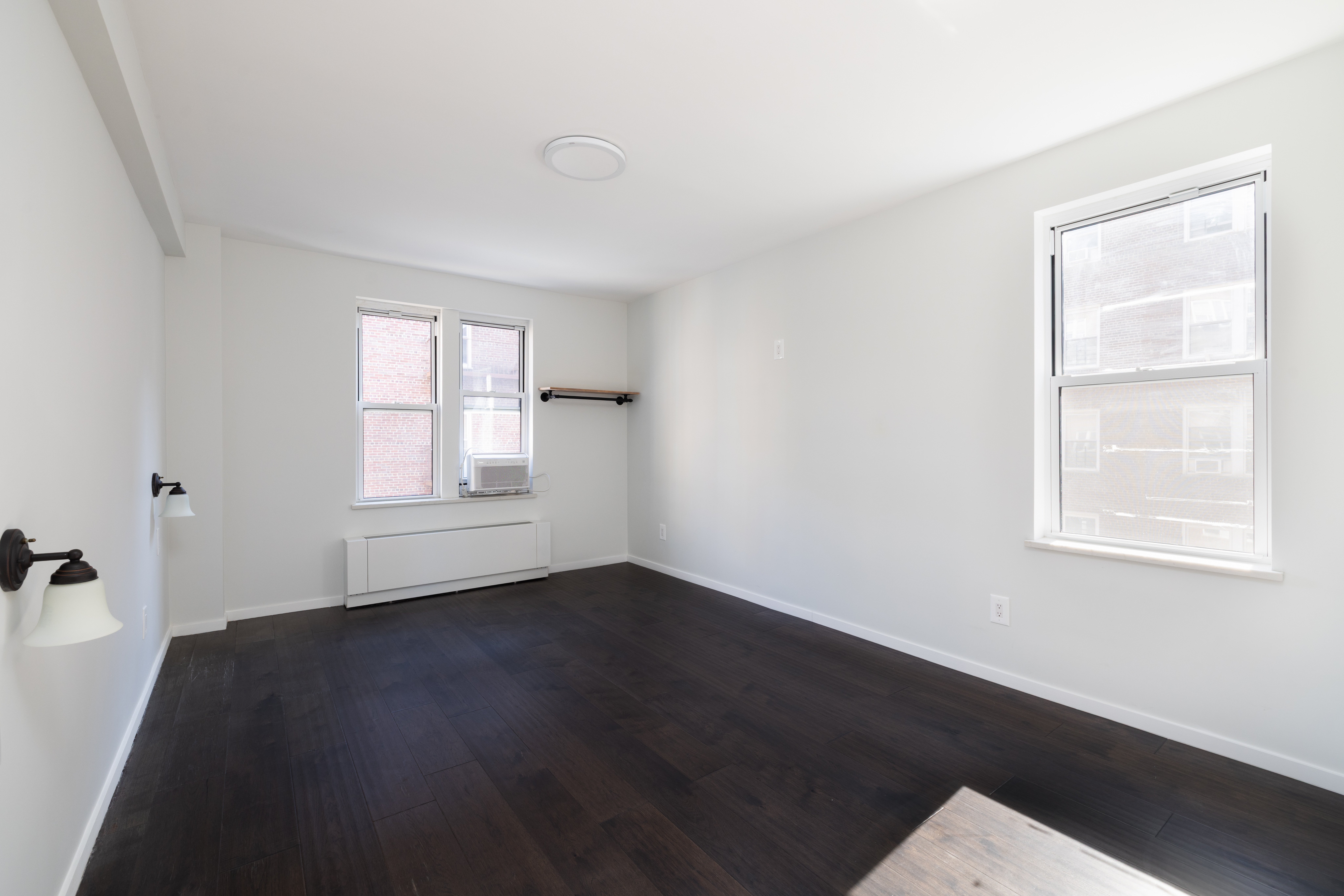 71-36 110th Street, Unit 4C Queens, NY 11375 - Photo 10 of 14 a view of an empty room with wooden floor and a window