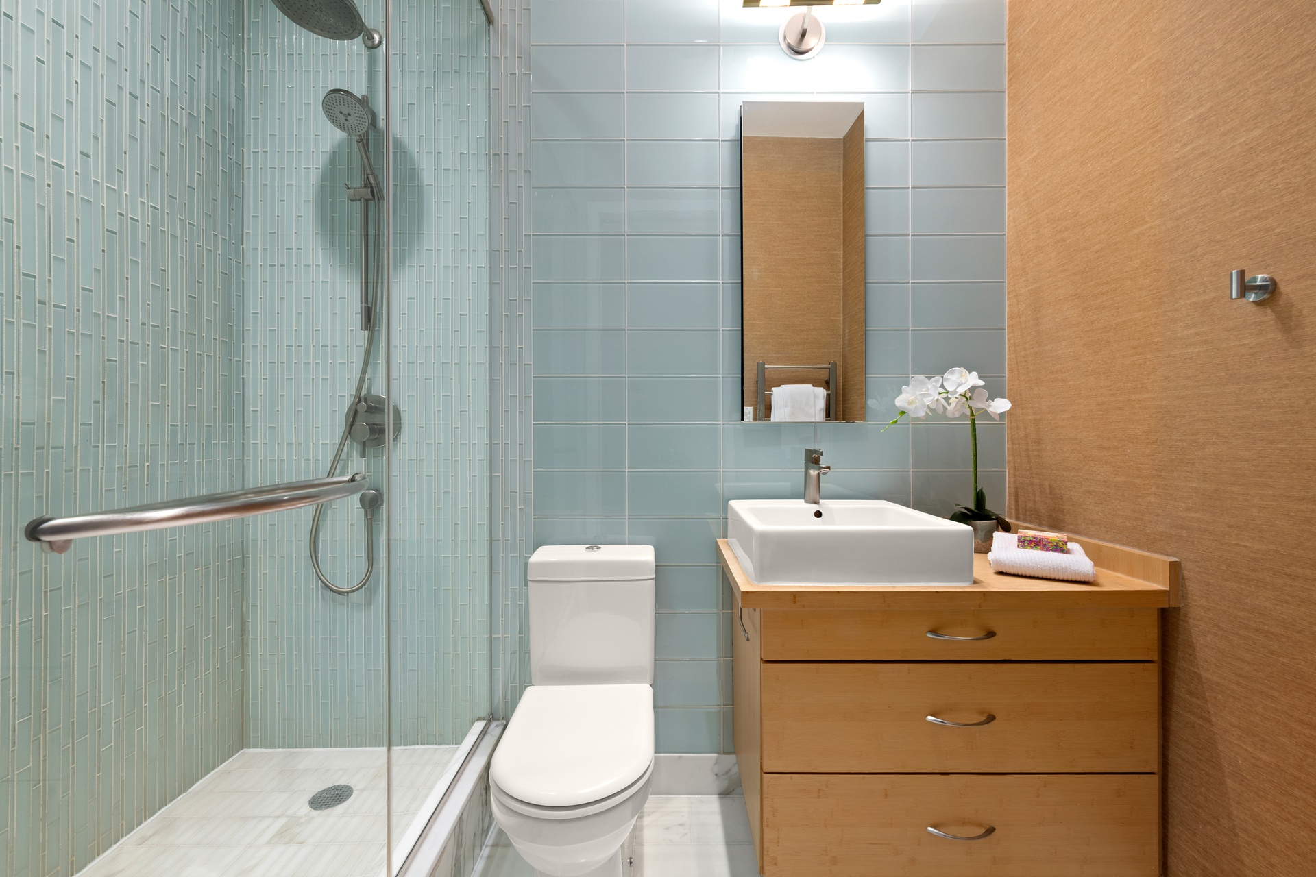 303 Mercer Street, Unit A406 Manhattan, NY 10003 - Photo 7 of 11 a bathroom with a sink a toilet and shower