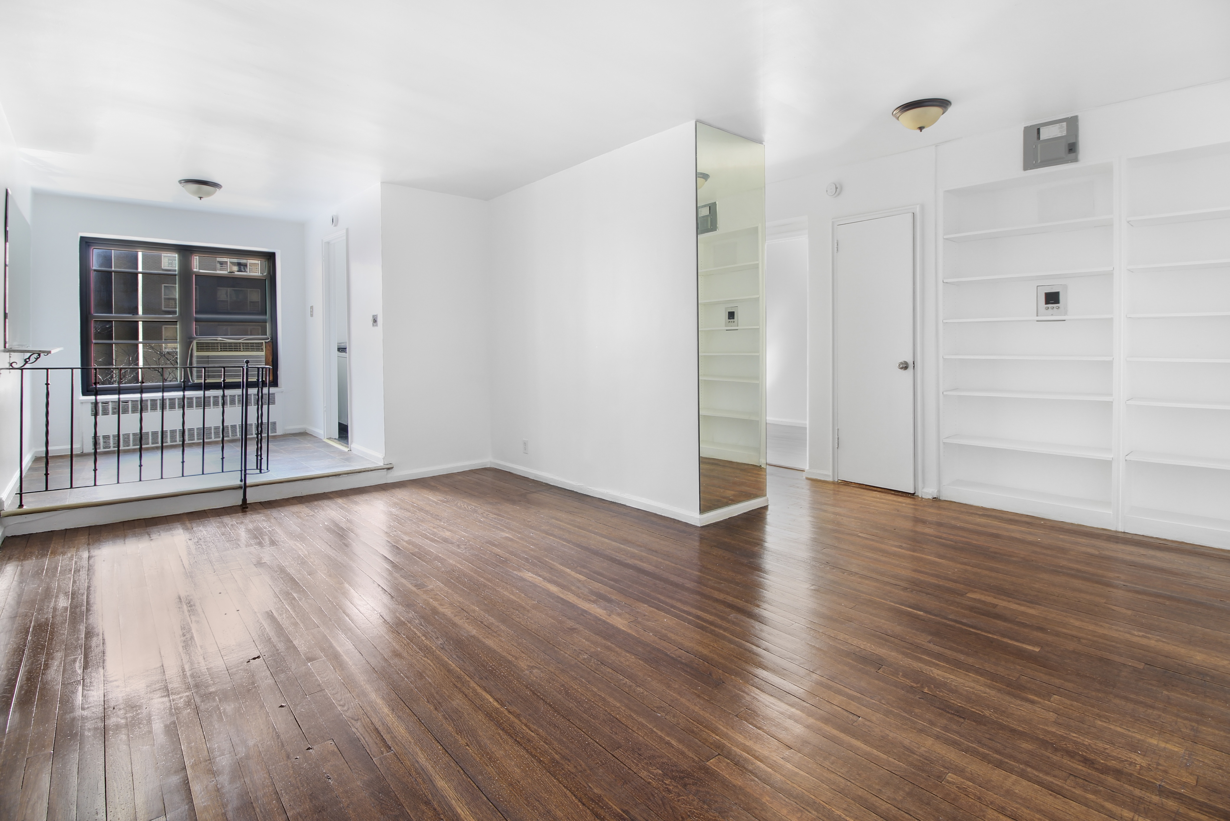 315 East 56th Street, Unit 5H Manhattan, NY 10022 - Photo 2 of 9 wooden floor in an empty room with a window