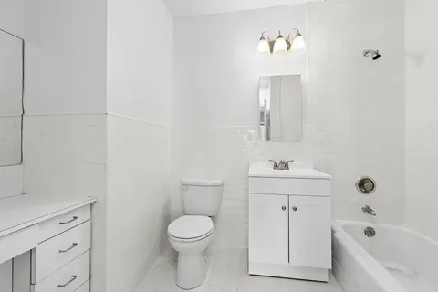 a bathroom with a toilet a sink a mirror and bathtub