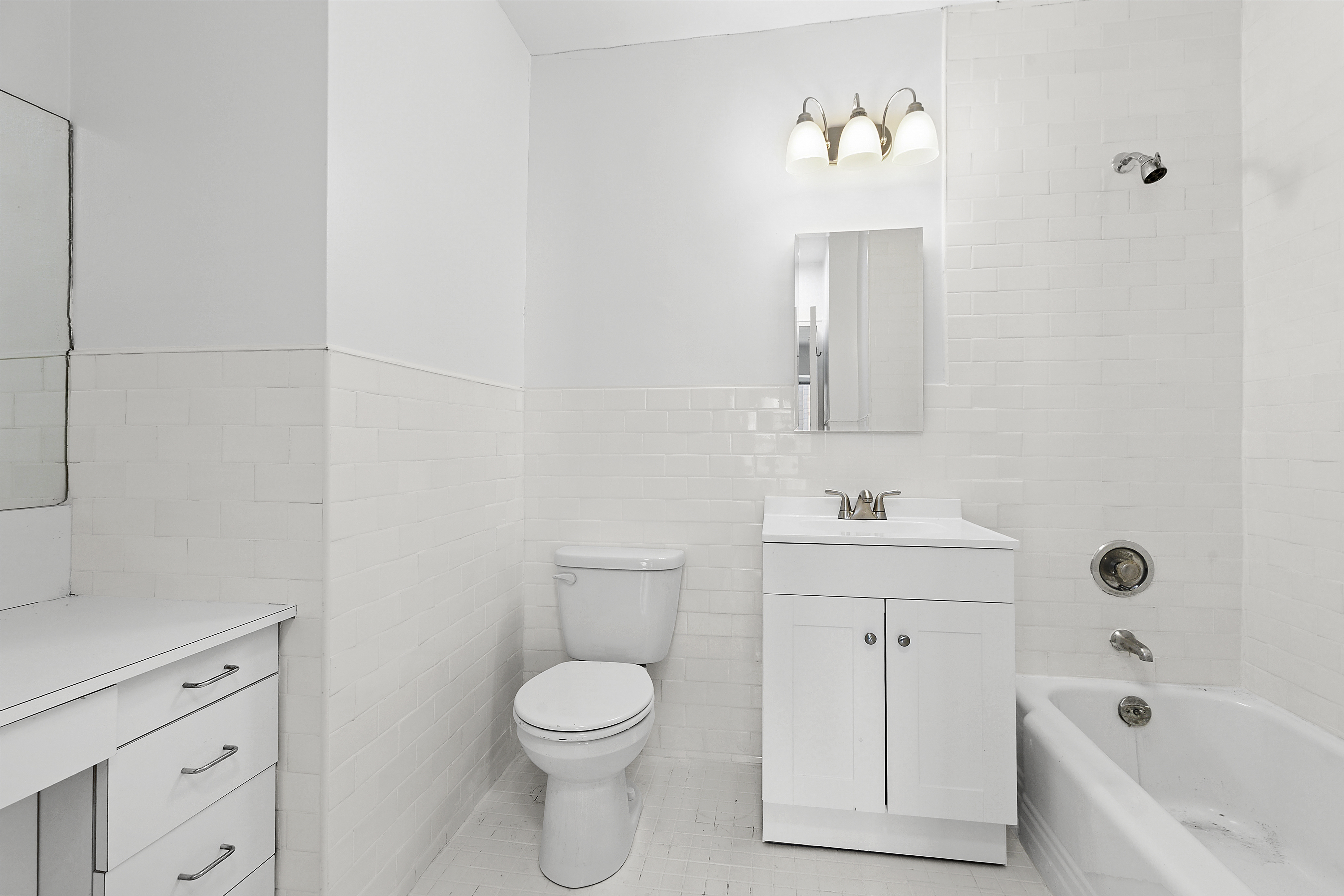 118 East 60th Street, Unit 32F Manhattan, NY 10022 - Photo 5 of 6 a bathroom with a toilet a sink a mirror and bathtub